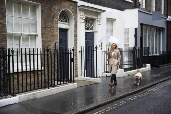mature-woman-walking-her-dog-city-streets-while-it-rains